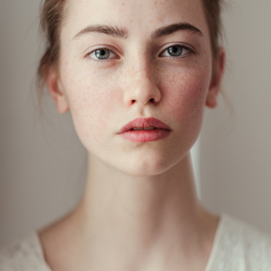 Portrait of young woman with freckles in Georgetown TX by joslin medical spa